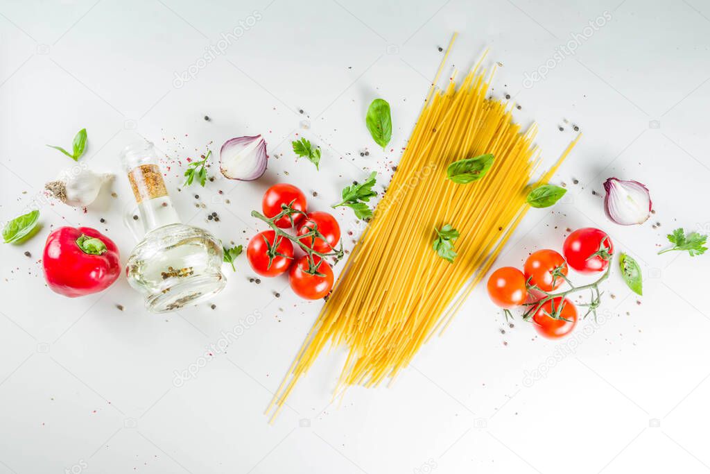 Traditional ingredients food  spaghetti pasta. Mediterranean italian dinner concept background. Dried pasta, garlic, olive oil, basil, tomatoes. White stone background. Top view with copy space.