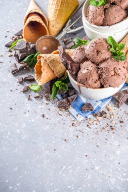 Ev yapımı çikolatalı dondurma, çikolata parçaları, talaş ve dondurma külahları. Beyaz gri taş masa üzerindeki küçük beyaz kaselerde fotokopi alanı