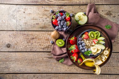 Kahvaltı yulafı. Sabah yulaf ezmesi, çeşitli meyve ve meyveler, kırsal ahşap arka plan fotokopi alanı