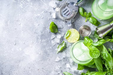 Fesleğen, alkollü cin kokteyli. Taze fesleğen yaprakları ve limonlu uzun alkollü içecek tarifi, gri taş arka plan fotokopi alanı