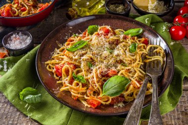 Geleneksel İtalyan makarna marinara. Klasik Roma yemeği tarifi. Ahşap arka planda fesleğen yapraklı makarna.