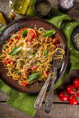 Geleneksel İtalyan makarna marinara. Klasik Roma yemeği tarifi. Ahşap arka planda fesleğen yapraklı makarna.
