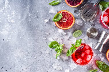 Taze kanlı portakallar, fesleğen yaprakları ve votka, gri taş beton arka plan düz fotokopi alanı.