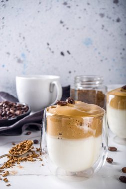 Moda içeceği, dalgona kahvesi. Kremalı kahve, soğuk süt ve şekerli. Yumuşak kremalı kahve içeceği, beyaz arka planda, boşluğu kopyala