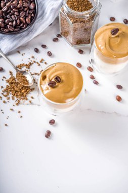 Moda içeceği, dalgona kahvesi. Kremalı kahve, soğuk süt ve şekerli. Yumuşak kremalı kahve içeceği, beyaz arka planda, boşluğu kopyala