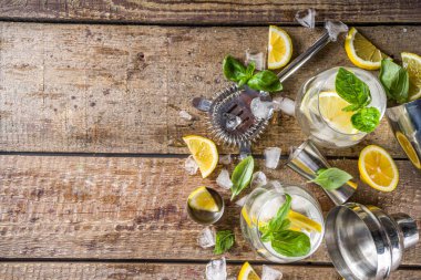 Limonata, taze fesleğen yaprağı, limon ve ezilmiş buz, sade ahşap arka plan kopyalama alanı.