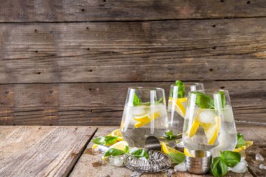 Limonata, taze fesleğen yaprağı, limon ve ezilmiş buz, sade ahşap arka plan kopyalama alanı.