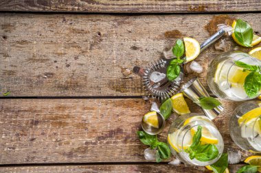 Limonata, taze fesleğen yaprağı, limon ve ezilmiş buz, sade ahşap arka plan kopyalama alanı.