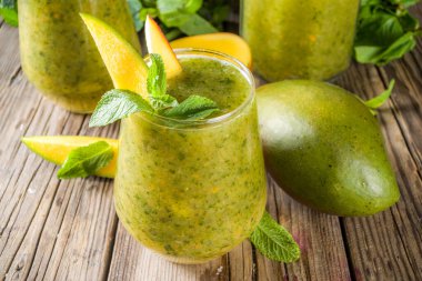 Alışılmadık yaz ferahlatıcı içecek. Hint geleneksel tuzlu limonata aam panna (aam panha) kokteyli, naneli ve yeşil mangolu. Hint mango mojito 'su. Mango ve naneli ahşap bir arka planda