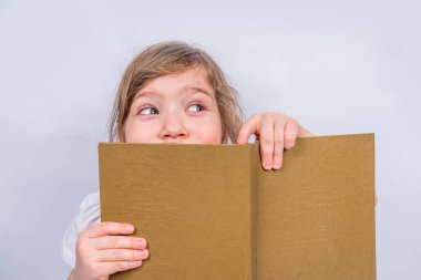 Okul konseptine geri dönelim. Eğitim geçmişi. Kitapları, büyüteçleri ve defterleri olan tatlı bir kız çocuğu. Kitap okuyan bir kız çocuğu. Beyaz gri arkaplanda, pankart maket yap, boşluk kopyala
