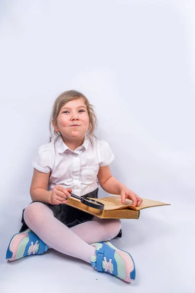 Back to school concept background. Education background. Little cute kid girl with books, magnifying glass and notebooks. Child girl reading a book. On white gray background, banner mock up, copy space