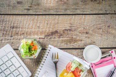 Sağlıklı bir ofis yemeği. Cam kavanozlarda vejetaryen sebze salatası ve dilimlenmiş taze sebzeler. Detoks, çiğ yemek ve sıfır ziyan öğle yemeği konsepti.