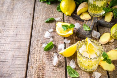 Ev yapımı zencefilli limonata kokteyli. Soğuk yaz zencefilli limonlu bira. Limon dilimi garnitür, detoks ve kilo verme içeceği konseptiyle tatlı ve ekşi buzlu içecek. Ahşap kırsal arkaplan kopyalama uzayı