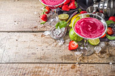 Yaz soğuk alkol içeceği. Çilekli margarita kokteyli, kireç, nane ve ahşap arka planda taze çilek.
