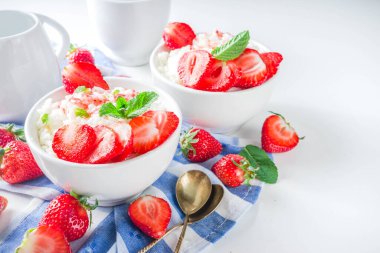 Yaz sabahı sütlü pirinç pudingi ya da çilekli pirinç lapası ve küçük bir kasede çilek şurubu, süt ve taze çilek fotokopi alanı.