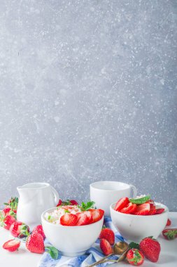 Yaz sabahı sütlü pirinç pudingi ya da çilekli pirinç lapası ve küçük bir kasede çilek şurubu, süt ve taze çilek fotokopi alanı.