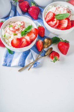 Yaz sabahı sütlü pirinç pudingi ya da çilekli pirinç lapası ve küçük bir kasede çilek şurubu, süt ve taze çilek fotokopi alanı.
