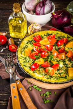 Ev yapımı rustik frittata. Tavada ıspanaklı, peynirli ve domatesli frittata. Sebzeli ahşap arkaplan Kopya alanı