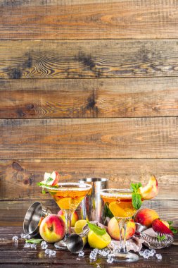 Ferahlatıcı yaz içeceği, şeftalili martini kokteyli cin veya votka ve taze şeftalili garnitür, ahşap arka plan fotokopi alanı.