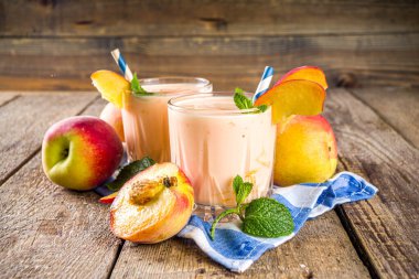 Yaz kahvaltısı içeceği, taze şeftalili smoothie, şeftalili yoğurt nektarin dilimleri, kırsal ahşap arka plan fotokopi alanı.