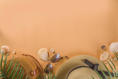 Moda elbisesi, hasır şapka, bambu çanta, güneş gözlüğü, şeftali rengi arka plan, üst manzara, fotokopi alanı, düz yatak. Yaz modası, tatil konsepti