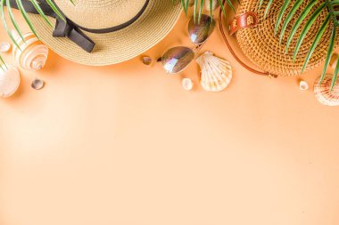 Moda elbisesi, hasır şapka, bambu çanta, güneş gözlüğü, şeftali rengi arka plan, üst manzara, fotokopi alanı, düz yatak. Yaz modası, tatil konsepti