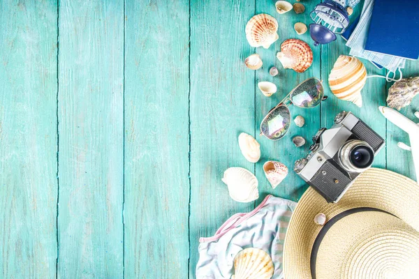 Bright  summer flat-lay background. Old blue wooden background with with summer woman clothes, sun glasses, hat, camera, passports and vacation tickets