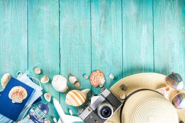 Bright  summer flat-lay background. Old blue wooden background with with summer woman clothes, sun glasses, hat, camera, passports and vacation tickets