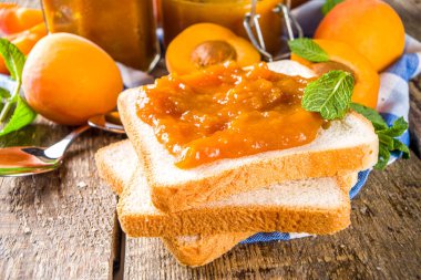 Farklı kavanozlarda ev yapımı kayısı reçeli, ahşap arka planda taze organik kayısılar fotokopi alanı