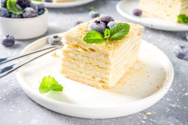 Ev yapımı kek Napolyon, Millefeuille. Böğürtlenli ve naneli kremalı kek. Gri beton bir arka planda.