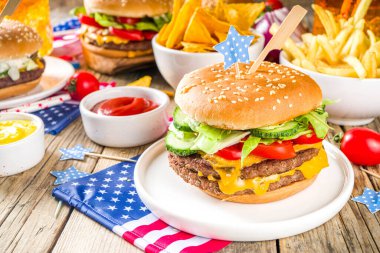 4 Temmuz Bağımsızlık Günü 'nü kutluyoruz. Geleneksel Amerikan Anma Günü pikniği hamburger, patates kızartması ve abur cubur, yaz pikniği ve bbq konsepti, eski ahşap arka plan. 