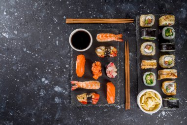 Japon yemeği. Büyük suşi seti. Çeşitli sashimi çeşitleri, maki ve suşi sarmaları farklı dolgularla - ton balığı, levrek, somon, karides, sebze. Düz kopyalama alanı