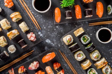 Japon yemeği. Büyük suşi seti. Çeşitli sashimi çeşitleri, maki ve suşi sarmaları farklı dolgularla - ton balığı, levrek, somon, karides, sebze. Düz kopyalama alanı