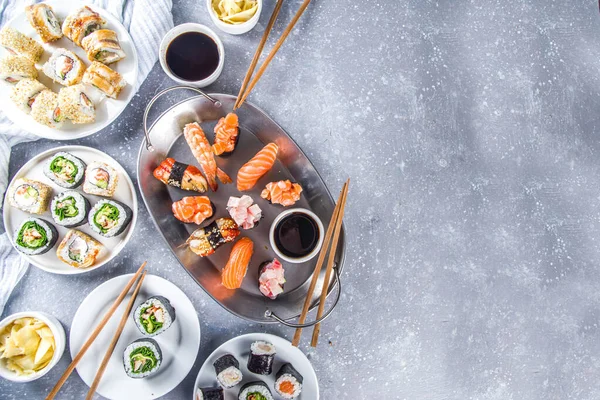 Japanese food. Big sushi set. Assorted set of various sashimi, maki and sushi rolls with different fillings - tuna, sea bass, salmon, shrimp, vegetables. Flatlay copy space