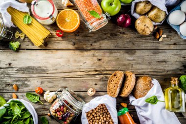 Atık alışveriş ve sustanable yaşam tarzı kavramı, çeşitli çiftlik organik sebzeler, tahıl, makarna, yumurta ve meyve yeniden kullanılabilir ambalaj süpermarket Çantalar sıfır. Kopyalama alanı üstten görünüm, ahşap arka plan