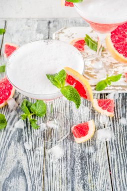 Yaz trendi alkollü içki. Soğuk narenciye martini kokteyli. Aperol spritz, taze greyfurt ve nane ile. Ahşap beyaz arka plan, kopyalama alanı