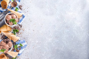 Ev yapımı çikolatalı dondurma, çikolata parçaları, talaş ve dondurma külahları. Beyaz gri taş masa üzerindeki küçük beyaz kaselerde fotokopi alanı
