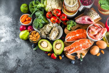 Pescetarian diyet planı maddeler, sağlıklı dengeli bakkal gıda, taze meyve, çilek, balık ve kabuklu deniz ürünleri istiridye, siyah taş beton arka plan kopya alanı