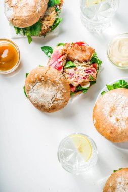 Çeşitli deniz ürünleri ve balık burger çeşitleri. Izgara karides, somon, ton balığı, levrek, taze otlar, mozzarella peyniri ve bebek ıspanağı ile ev yapımı sağlıklı burger.. 