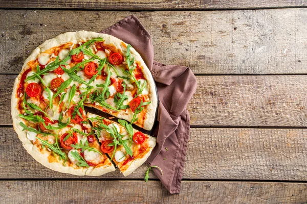 Flatbread homemade vegan pizza. Italian classic pizza with tomato cherry, mozzarella cheese and fresh arugula, copy space