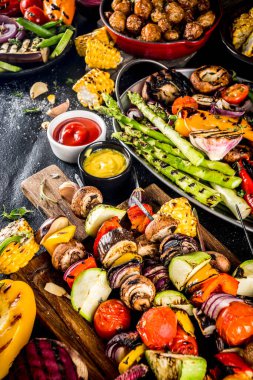 Çeşitli barbekü vejetaryen yemekleri, ızgara sebzeler, sebzeli bbq parti festivali ızgara mısır, vejetaryen şiş kebabı, soslu ve baharatlı sıcak sebze salatası. Vejetaryen mevsimlik yaz yemekleri