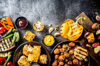 Çeşitli barbekü vejetaryen yemekleri, ızgara sebzeler, sebzeli bbq parti festivali ızgara mısır, vejetaryen şiş kebabı, soslu ve baharatlı sıcak sebze salatası. Vejetaryen mevsimlik yaz yemekleri