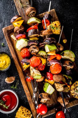 Vejetaryen barbekü partisi konsepti. Sebze diyeti kebabı, çeşitli sebzeler ve şişler. Şişte ızgara sebzeler - kabak, domates, biber, patlıcan, mantar, soslu