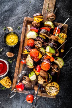 Vejetaryen barbekü partisi konsepti. Sebze diyeti kebabı, çeşitli sebzeler ve şişler. Şişte ızgara sebzeler - kabak, domates, biber, patlıcan, mantar, soslu