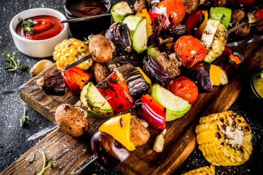 Vejetaryen barbekü partisi konsepti. Sebze diyeti kebabı, çeşitli sebzeler ve şişler. Şişte ızgara sebzeler - kabak, domates, biber, patlıcan, mantar, soslu