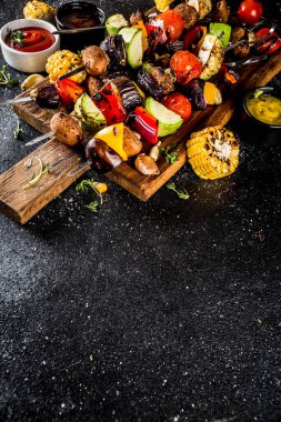 Vejetaryen barbekü partisi konsepti. Sebze diyeti kebabı, çeşitli sebzeler ve şişler. Şişte ızgara sebzeler - kabak, domates, biber, patlıcan, mantar, soslu