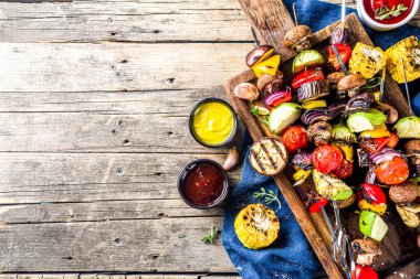 Vejetaryen barbekü partisi konsepti. Sebze diyeti kebabı, çeşitli sebzeler ve şişler. Şişte ızgara sebzeler - kabak, domates, biber, patlıcan, mantar, soslu