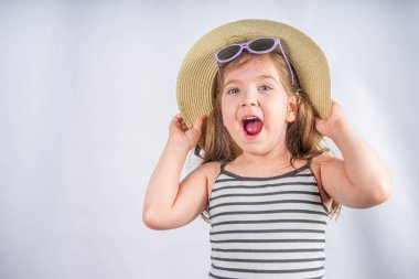 Yaz tatili ve tatil konsepti. Güneş gözlüklü, yaz şapkalı, gülümseyen tatlı bir kız. Tatil afişi için arka plan, model