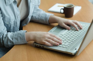 Kadın bir dizüstü bilgisayar evde çalışıyor