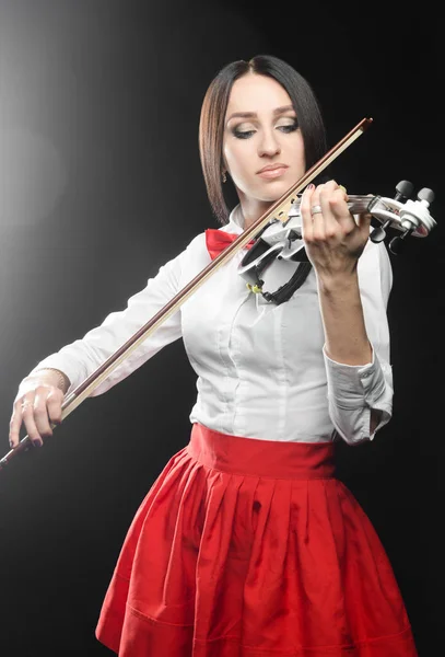 Güzel kadın siyah bir arka planda keman çalıyor 